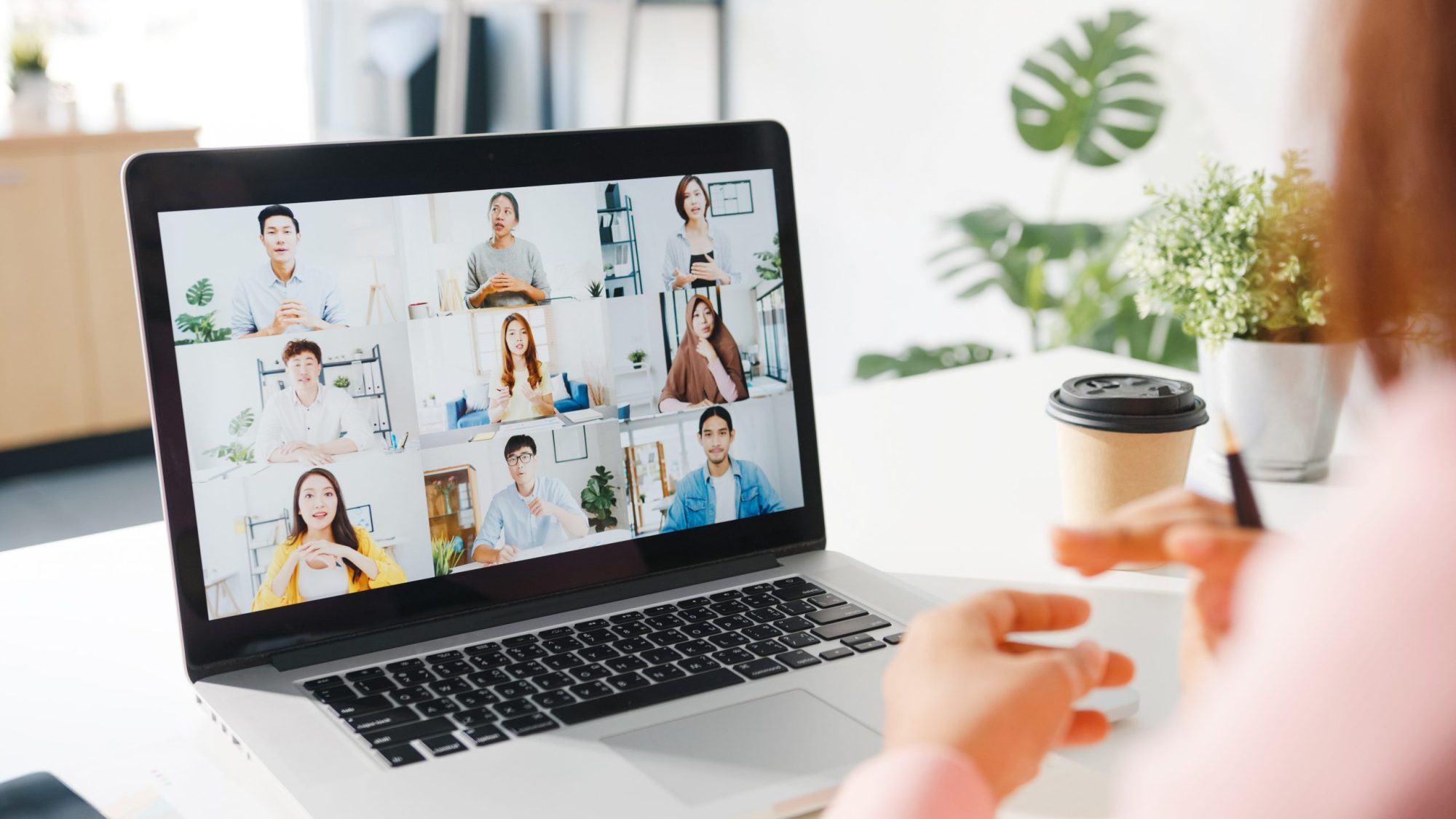 young asia businesswoman using laptop talk colleague about plan video call meeting while work from home living room scaled